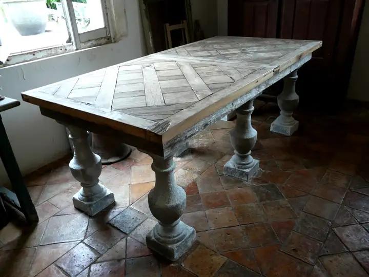 Table composée de 2 panneaux de parquet XVIII éme reversibles et de 6 balustres en pierre