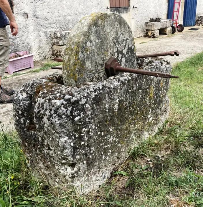 Ancienne meule á eau et son support en pierre creusé. Meule á aiguiser les couteaux accionnée par une manivelle en fer forgée