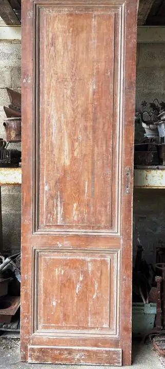 Ancienne porte pleine d'intérieur en bois á deux panneaux. Porte de communication en sapin rouge. particellement décapée