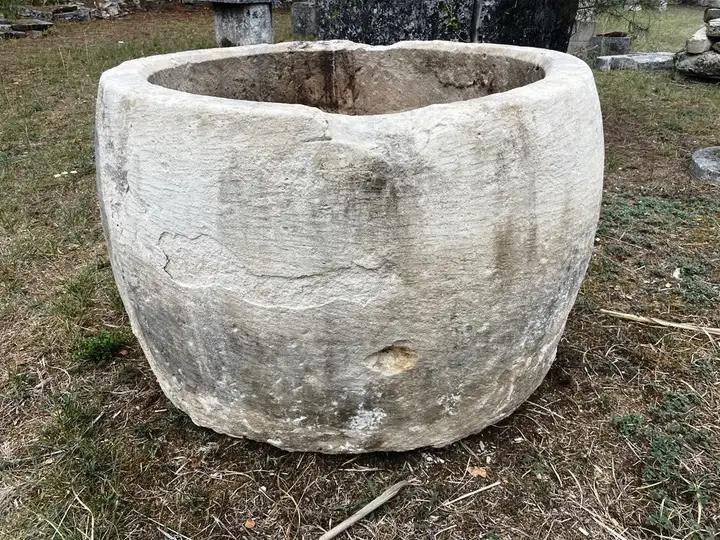 Ancienne ponne en pierre. Réceptacle servant á blanchir le linge. Bac en pierre de Charente de forme ovoide réemployé comme grosse jardinière