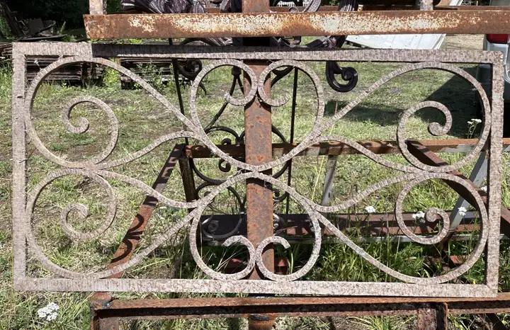 Petite grille de protection en fer forgé décorée d'enroulements