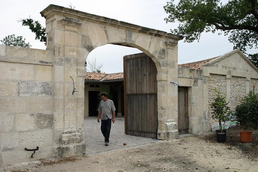 Porche charentais du 19ème siècle en pierre de Saint-Mème-les-carrières,composé d'un grand porche cintré et de sa porte cochère à linteau droit