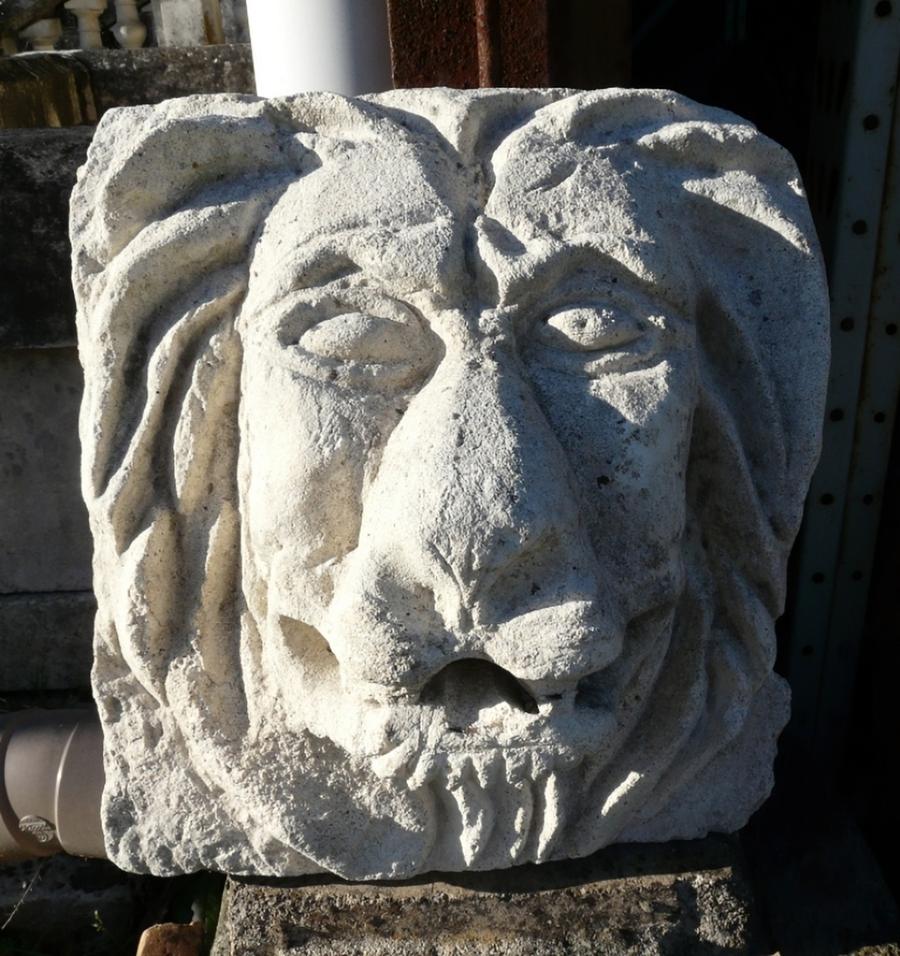 Tête de lion en pierre utilisée comme cracheur de fontaine