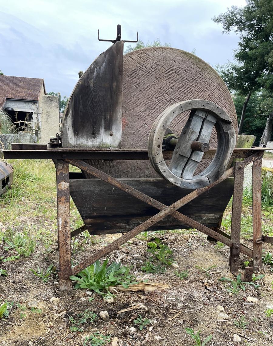 Ancienne meule à aiguiser en pierre dure montée sur une structure métailique